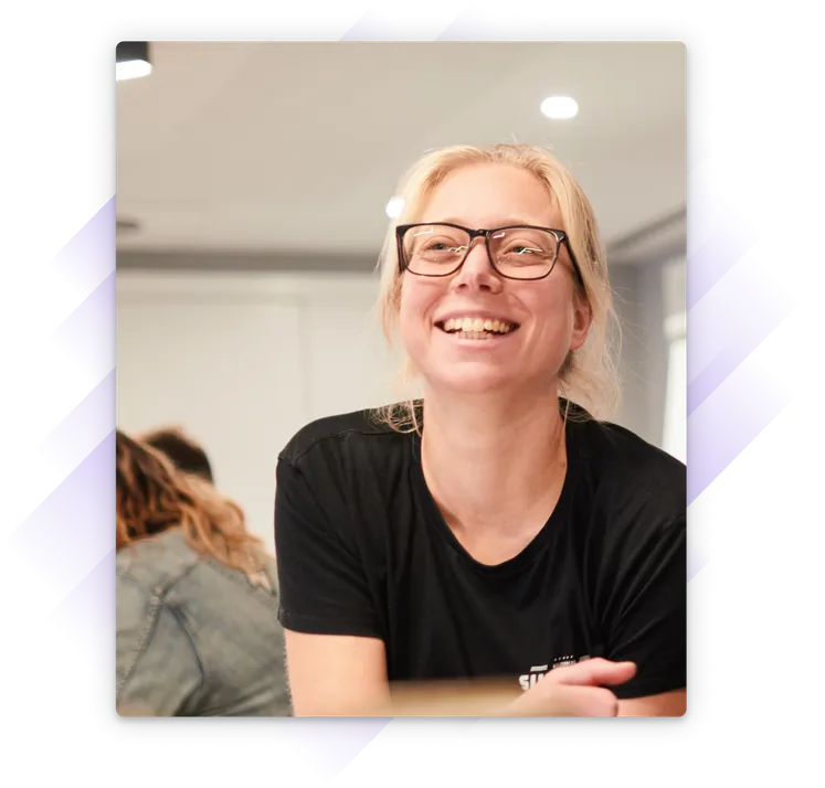Smiling blonde woman in a conference room smiling up to their right.
