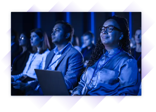 Group of professionals attentively watching a presentation at a training event.