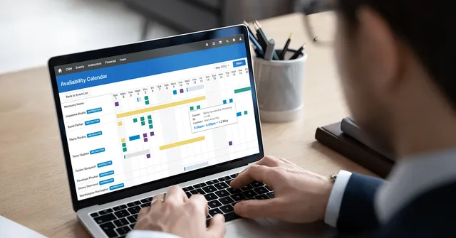 Training professional looking at the Availability Calendar feature of Administrate on their laptop.