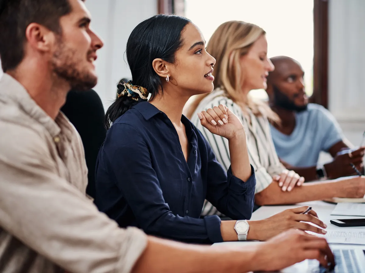 People in a corporate training session smiling and engaging with instructor led training.