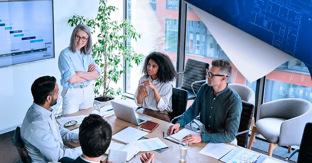 Five professionals in a modern office meeting around a conference table, with city views and data charts displayed on wall monitors.