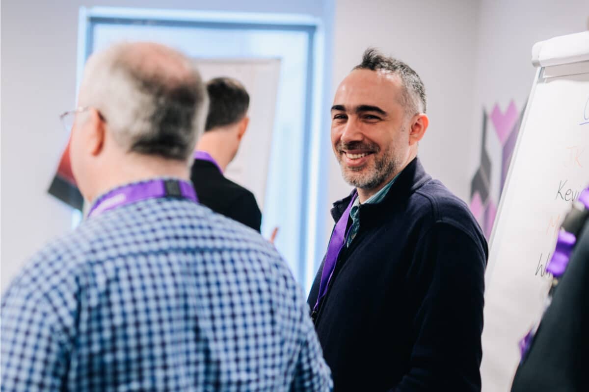 Administrate colleague having a discussion during a Customer Summit and wearing an Administrate lanyard.