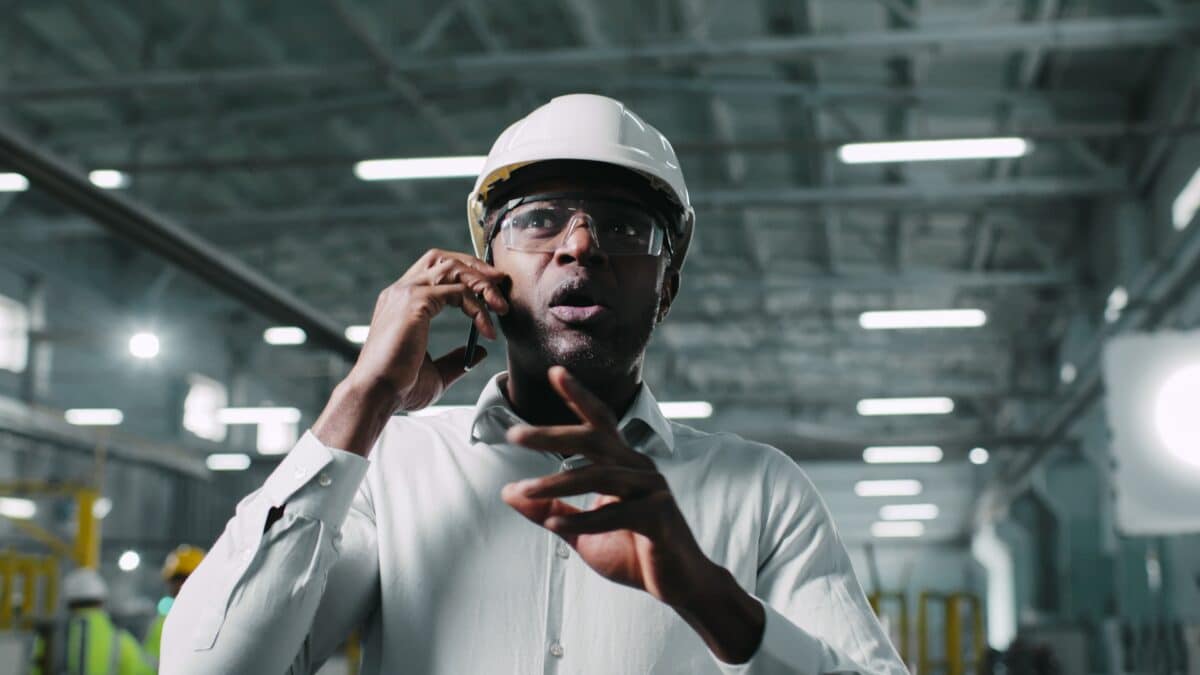 Manufacturing engineer energetically gesticulating during phone call with a customer.