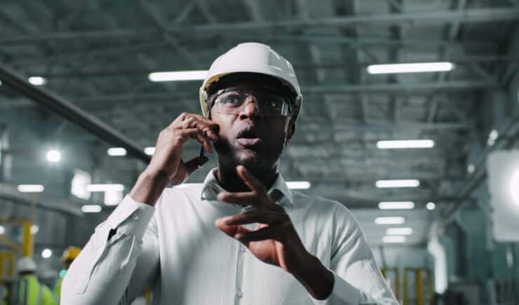 Manufacturing engineer energetically gesticulating during phone call with a customer.