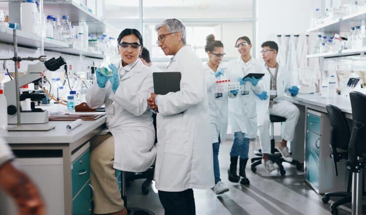 Learners in lab coats train in a specialized lab.