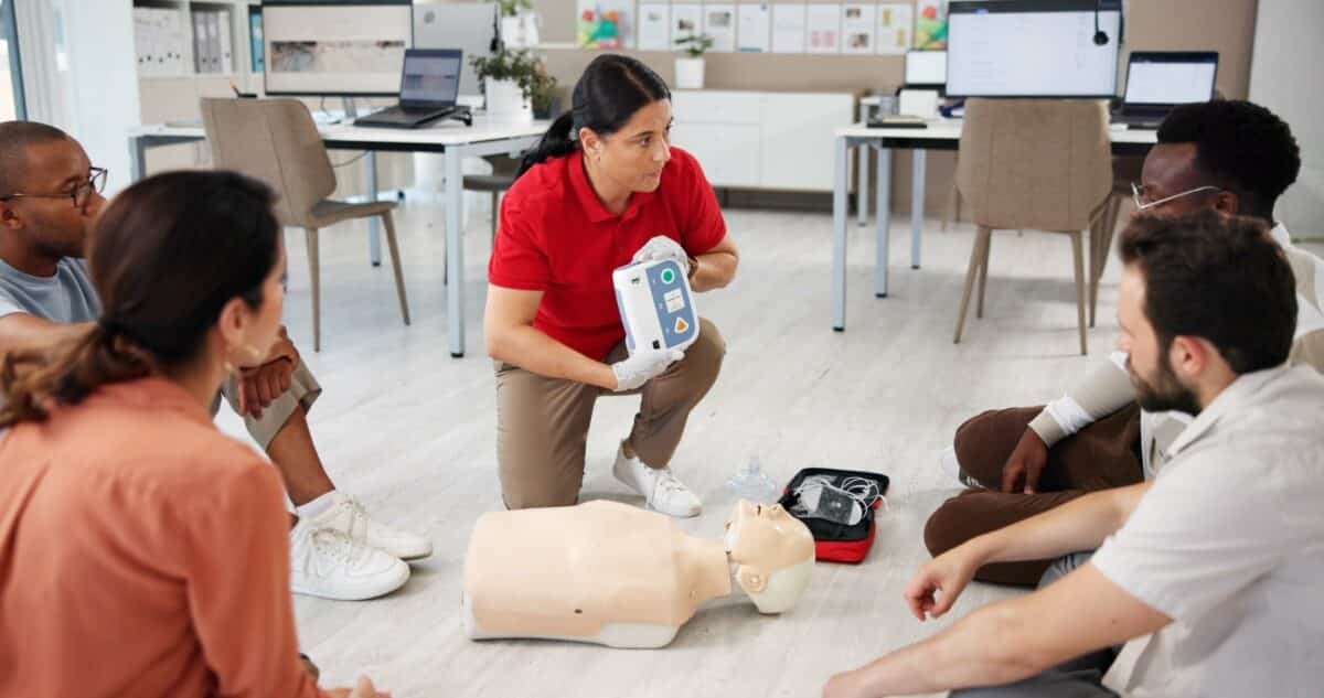 Learners attend a safety course with an instructor giving a lesson on how to use medical equipment on a dummy.